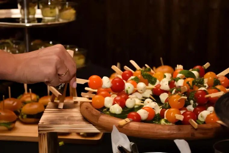 Hand nimmt einen Spieß vom Buffet
