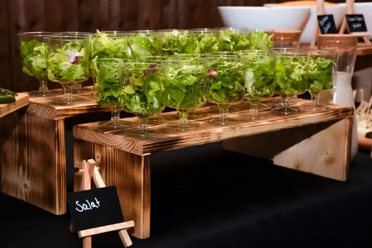 Salat im Glas auf Holzbock